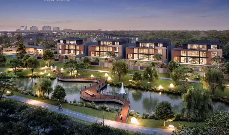Pemandangan udara Island Villa saat senja — deretan villa yang menyala di tepi danau dengan boardwalk taman