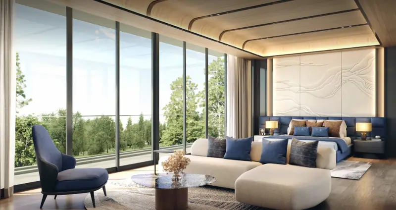 Kamar tidur utama grand suite dengan area duduk dan dinding kaca menghadap taman